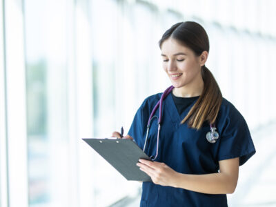 Smiling young female doctor holding a clipboard in hospital. healthcare concept